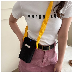 Minimalist black corduroy crossbody bag with adjustable bright yellow shoulder strap