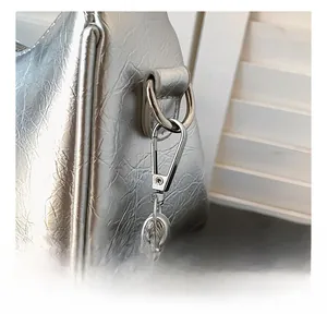 Detail of silver metallic crescent bag showing heavy-duty round metal hook and strap