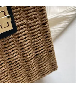 Macro detail of handwoven straw texture and golden metal clasp on a retro shoulder bag