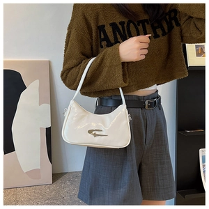 Close-up of minimalist white crescent underarm bag with silver geometric metal buckle