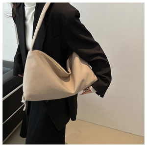 Detail of soft beige nylon hobo bag with sleek metal zipper and slender shoulder straps