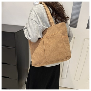 Braune Cord-Tragetasche mit großem Fassungsvermögen und Vordertasche am Model