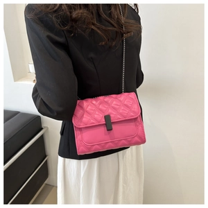 Classic fuchsia quilted crossbody bag with metal chain strap shown on fashion model
