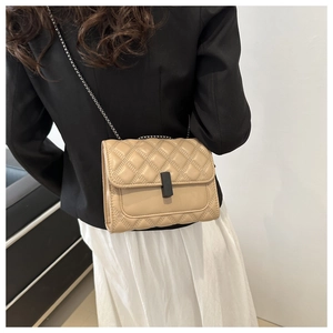 Back view of a beige quilted chain bag on model showing size and proportions