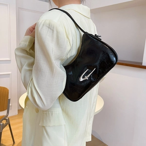 Minimalist black crescent underarm bag with cracked texture and silver shooting star detail