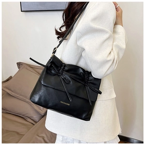Dettaglio borsa tote in pelle PU nera a pieghe con fiocco a coulisse e logo dorato