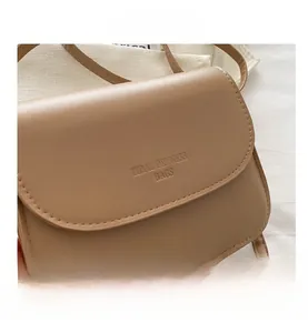 Close-up of khaki PU leather small square bag with detailed stitching and embossed logo