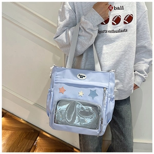 Dettaglio borsa tote in nylon azzurro con stelle colorate e tasca a rete frontale
