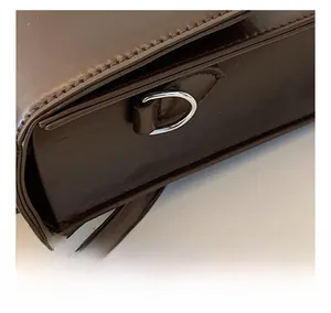 Detailed close-up of durable silver D-ring hardware on a dark brown messenger bag