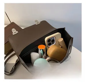 Top view of retro brown satchel interior showing large capacity for phone and cosmetics