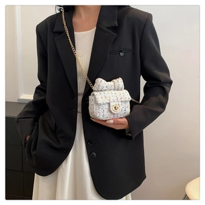 Mini tweed chain bag with bow detail and gold clasp shown worn on a crossbody strap