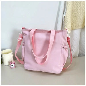 Dettaglio della borsa tote rosa con tasche laterali a coulisse e design a doppia tracolla