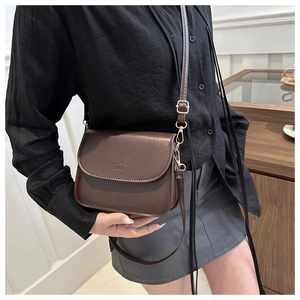 Détail d'un sac besace marron en cuir avec fermeture à rabat et bandoulière réglable