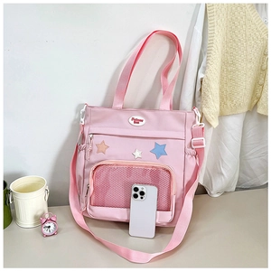 Dettaglio della borsa tote in tela rosa che mostra la capienza con un telefono