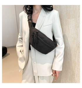 Detail of minimalist black nylon belt bag with woven zipper pulls and adjustable strap