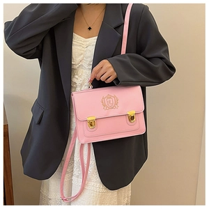 Detail of pink JK uniform messenger bag featuring embroidered crest and gold buckles