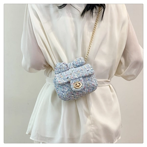 Detail of light blue tweed mini bag featuring a bow flap and gold chain strap