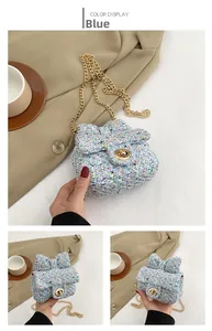 Detail of blue tweed girl bag with bow buckle and golden chain strap for kids