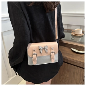 Detailed back view of a pink bow shoulder bag worn by a model in a cozy indoor setting