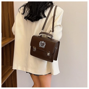 Rear view of a model wearing the brown vintage British style satchel backpack