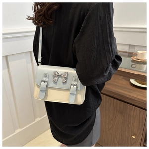 Détail du sac à main bicolore avec un nœud papillon en métal argenté et boucles