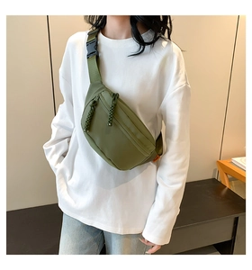 Detail of army green nylon chest bag featuring durable zippers and adjustable buckle strap