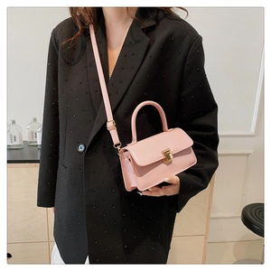 Detailansicht der rosa Mini-Vierecktasche mit Metallschnalle und verstellbarem Schultergurt