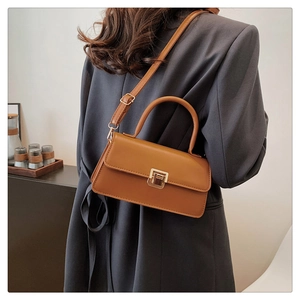Braune Vintage-Quadratische Tasche getragen am Modell mit Fokus auf Material und Textur