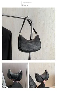 Detail view of black woven texture crescent underarm bag with gold metal zipper