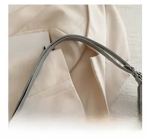 Detail of silver tote bag metallic strap with durable metal buckles and premium stitching