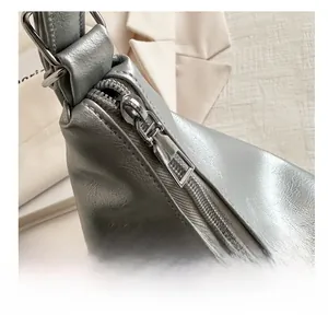 Macro detail of a smooth silver zipper on a minimalist large capacity tote bag