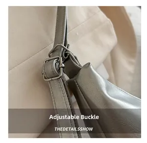 Close-up of adjustable silver metal buckle on metallic faux leather shoulder strap