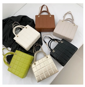 Flat lay of quilted chain crossbody bags in six colors with a stylish leather jacket