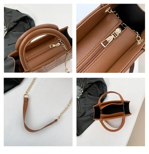 Detail of brown quilted faux leather bag with chain strap and gold zipper hardware