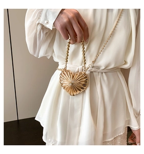 Détail du mini sac cœur en métal avec nervures radiales et bandoulière en chaîne billes