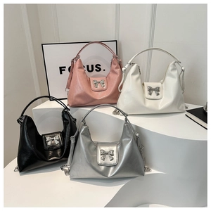 Detailed close-up of bow-knot metal buckles on multi-color glossy leather tote bags