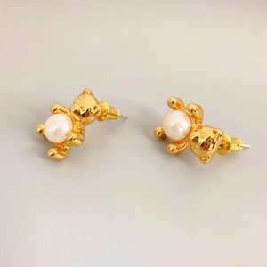 Golden bear stud earrings with pearl accent, polished finish in 45-degree view