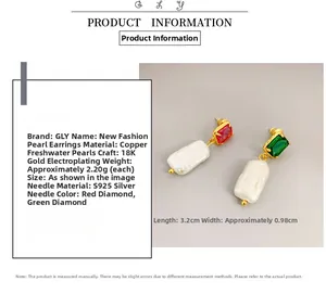 Detail view of long rectangular freshwater pearl earrings with red and green gemstone accents