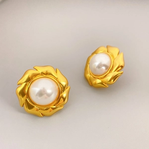 Boucles d'oreilles moulin à vent dorées avec perles blanches et design radial élégant