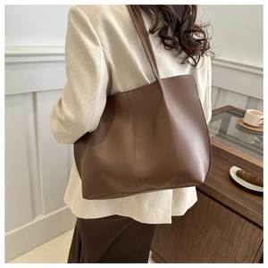 Brown PU leather tote bag with vertical stitching shown in a cafe setting