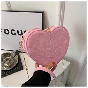 Detail of pink heart crossbody bag with spider web embroidery and gold chain strap