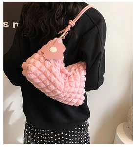 Detail of pink bubble texture shoulder bag featuring a cute flower charm and leather strap