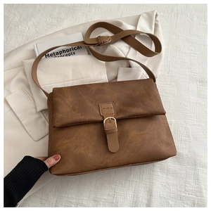 Détail du sac fourre-tout en cuir marron mat avec boucle rétro et texture vintage