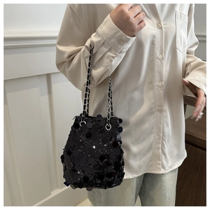 Detail of a sparkling black sequin bucket bag with a silver chain strap for parties