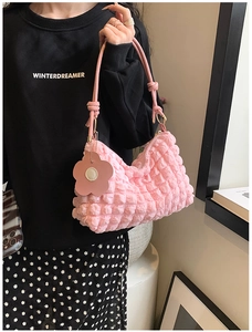 Pink bubble texture shoulder bag detail with floral charm and nylon popcorn fabric finish