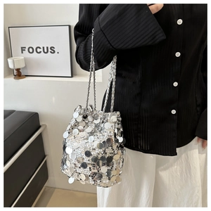 Detail of silver sequin bucket bag with metal chain strap in a stylish street style view