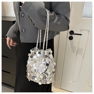 Silver sequin bucket bag with chain strap styled on a woman for party or evening events