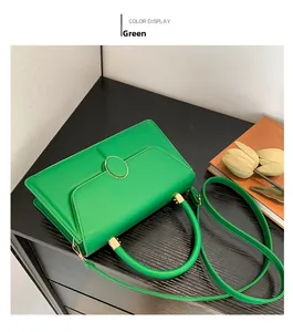 Dettaglio borsa a tracolla verde con fibbia ovale in metallo e tracolla staccabile