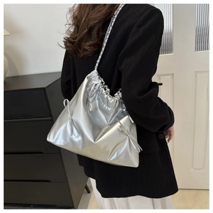 Detail of silver metallic tote bag with drawstring closure and delicate side bow accents