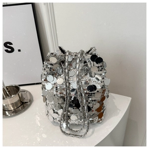 Detail of silver sequin bucket bag featuring a polished metal chain strap and reflective finish